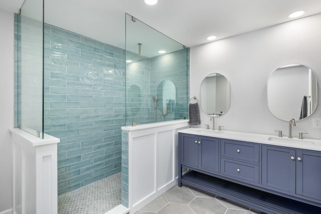 bathroom with tile patterned flooring, vanity, and tiled shower