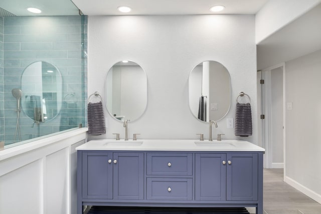 bathroom featuring walk in shower, vanity, and hardwood / wood-style flooring