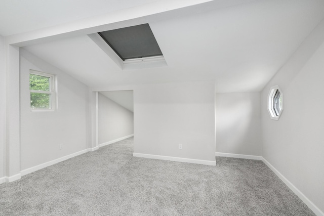 additional living space with a healthy amount of sunlight, carpet floors, and vaulted ceiling