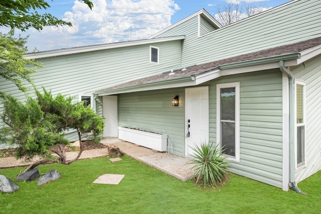 rear view of property featuring a lawn