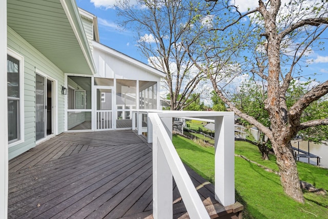 wooden deck with a sunroom and a yard