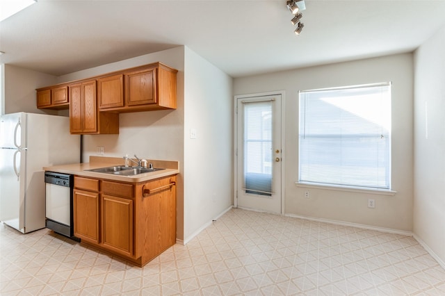 kitchen with dishwasher, white fridge, track lighting, and sink