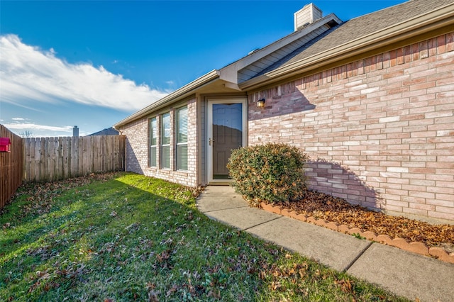 doorway to property with a lawn