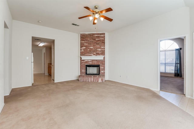 unfurnished living room featuring light colored carpet, a brick fireplace, and ceiling fan