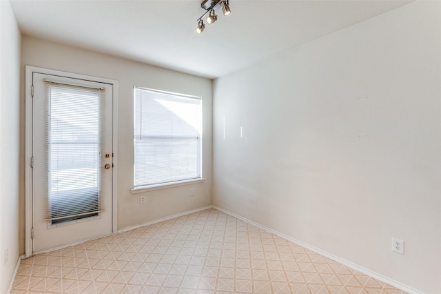 unfurnished room with a healthy amount of sunlight and track lighting