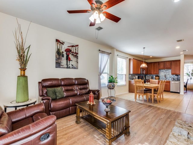 living room featuring ceiling fan, sink, and light hardwood / wood-style floors