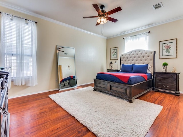 bedroom with ceiling fan, ornamental molding, and dark wood-type flooring