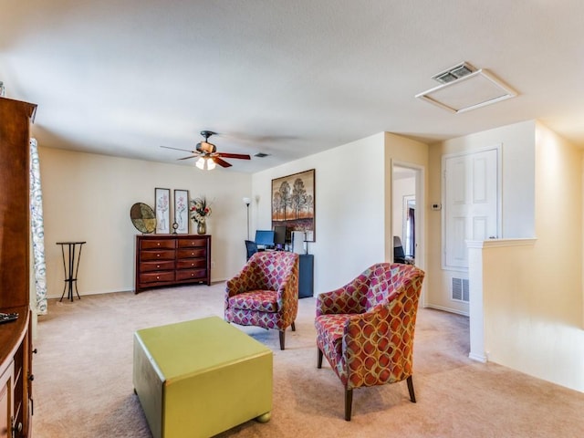 living area featuring light colored carpet and ceiling fan