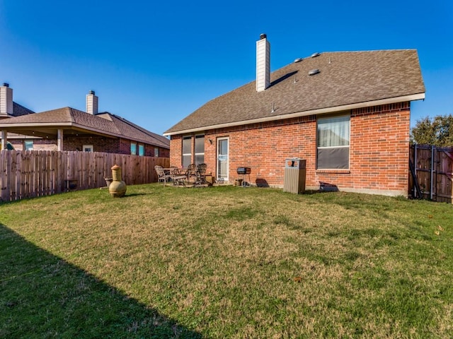 rear view of property with a yard