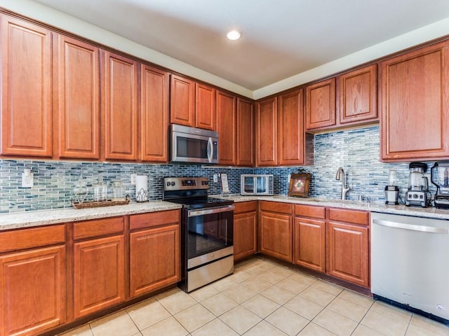 kitchen featuring light tile patterned flooring, sink, stainless steel appliances, and tasteful backsplash