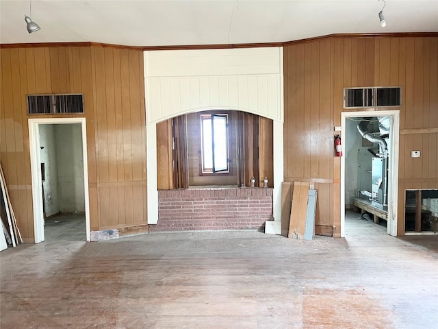 unfurnished living room featuring wooden walls