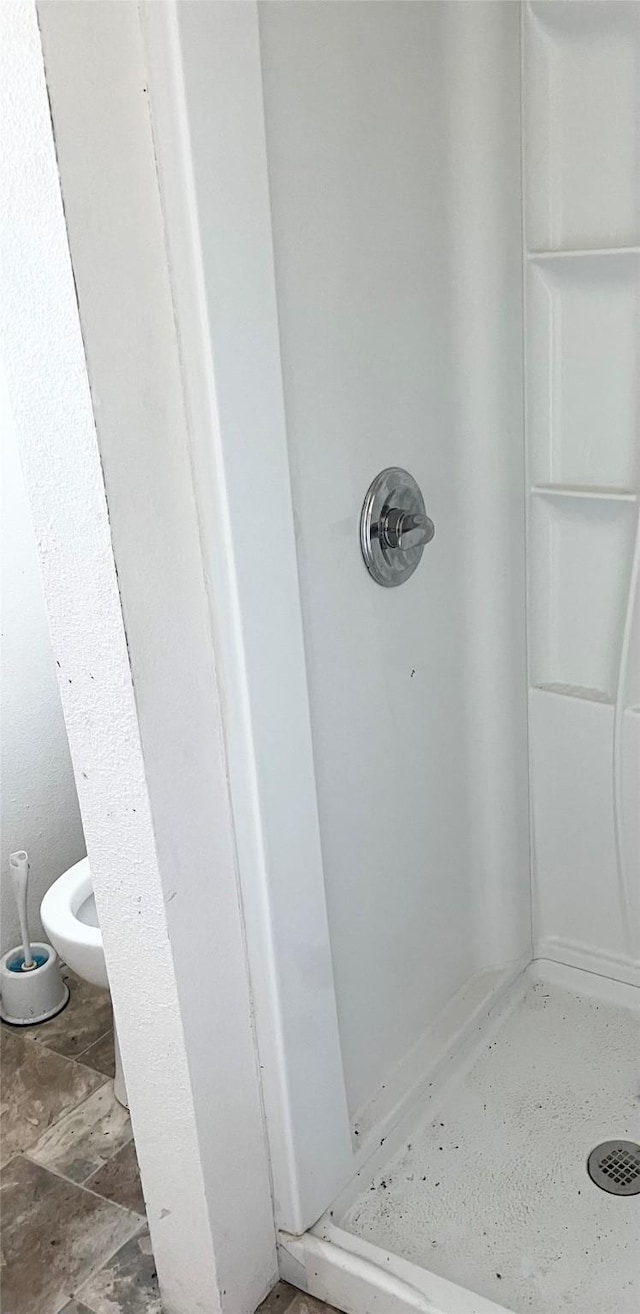 bathroom featuring toilet and walk in shower