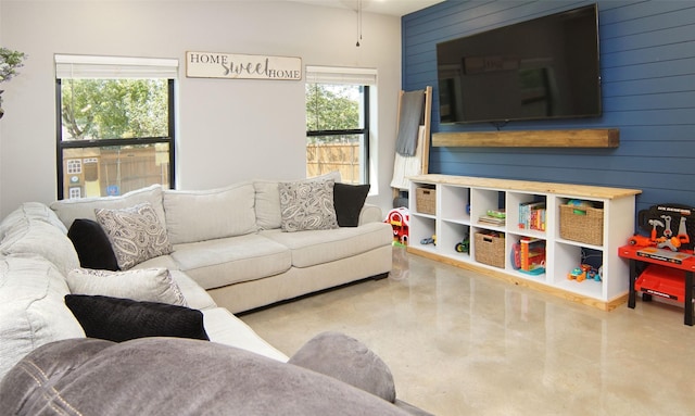 living room featuring concrete flooring and wood walls