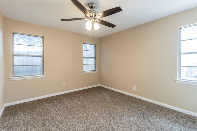 carpeted empty room featuring ceiling fan and a wealth of natural light