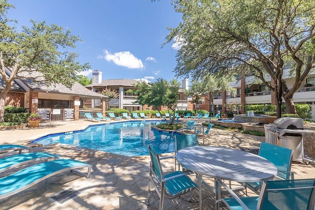 view of pool with a patio area and a grill