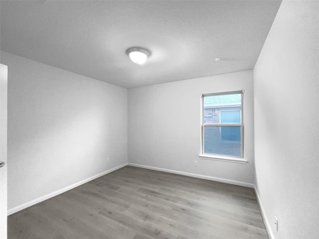 spare room with hardwood / wood-style floors and a textured ceiling