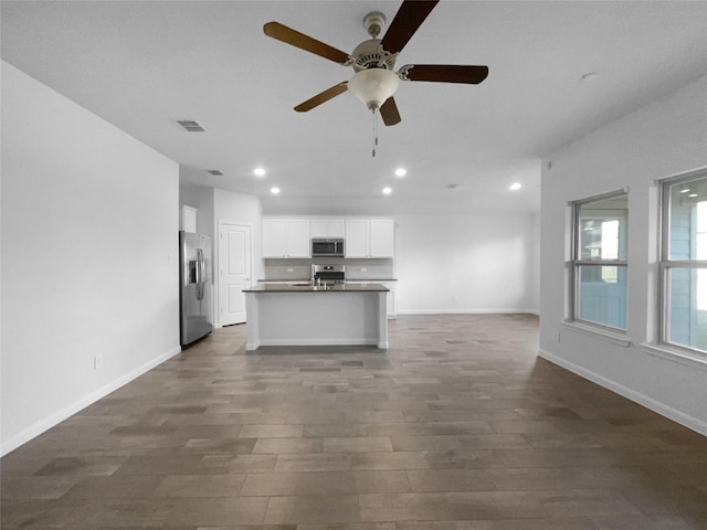 unfurnished living room with ceiling fan and dark hardwood / wood-style floors