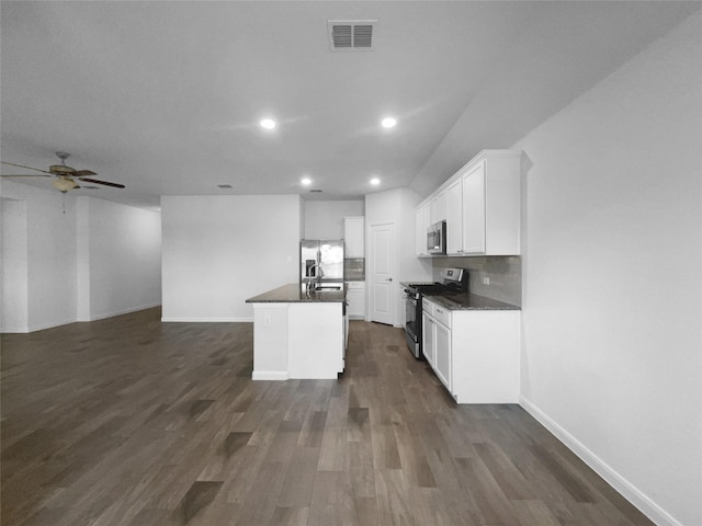 kitchen featuring appliances with stainless steel finishes, dark hardwood / wood-style floors, a kitchen island with sink, and white cabinets