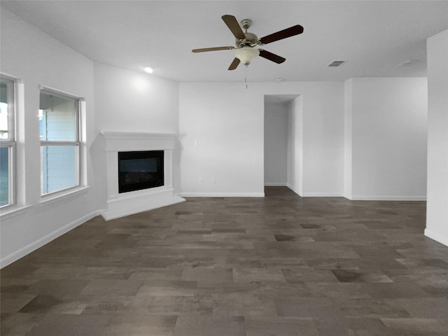 unfurnished living room with dark wood-type flooring and ceiling fan