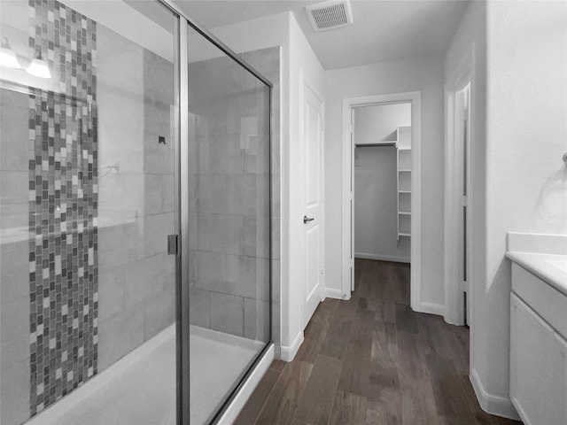 bathroom featuring a shower with door, vanity, and hardwood / wood-style floors