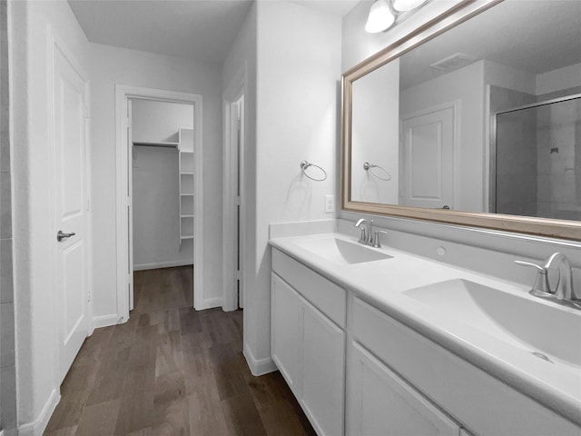 bathroom featuring wood-type flooring, an enclosed shower, and vanity