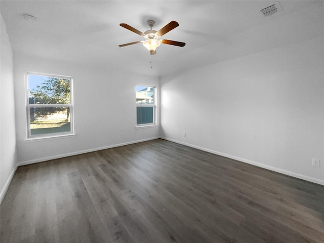 empty room featuring dark wood-type flooring and ceiling fan