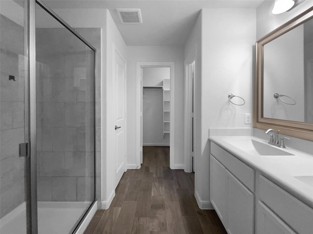 bathroom featuring walk in shower, wood-type flooring, and vanity