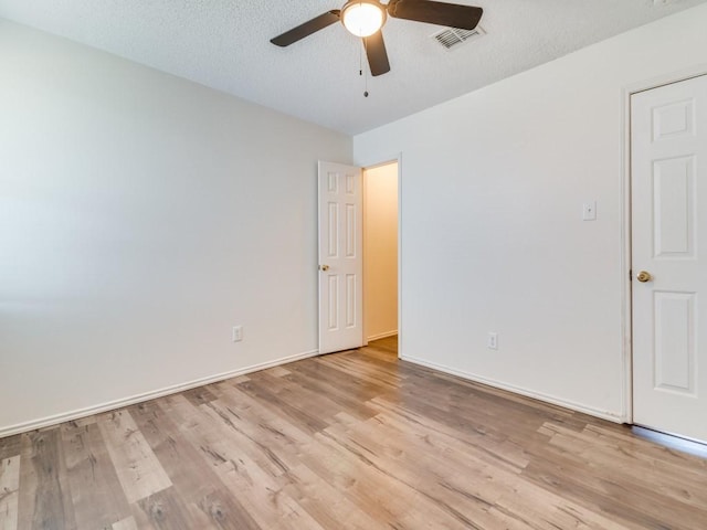 unfurnished room with ceiling fan, light hardwood / wood-style flooring, and a textured ceiling