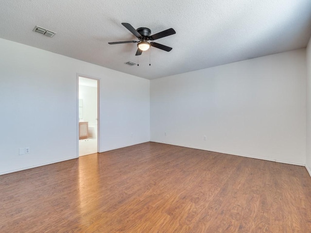 spare room with hardwood / wood-style floors, a textured ceiling, and ceiling fan