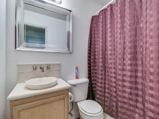 bathroom with vanity, curtained shower, toilet, and a textured ceiling