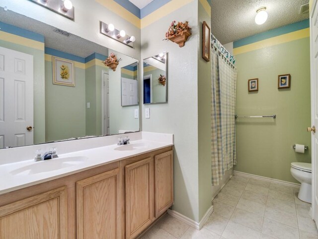 bathroom with a shower with shower curtain, vanity, toilet, and a textured ceiling