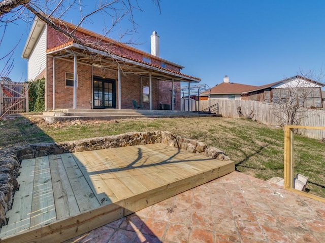 back of property featuring a patio area, a yard, and a wooden deck