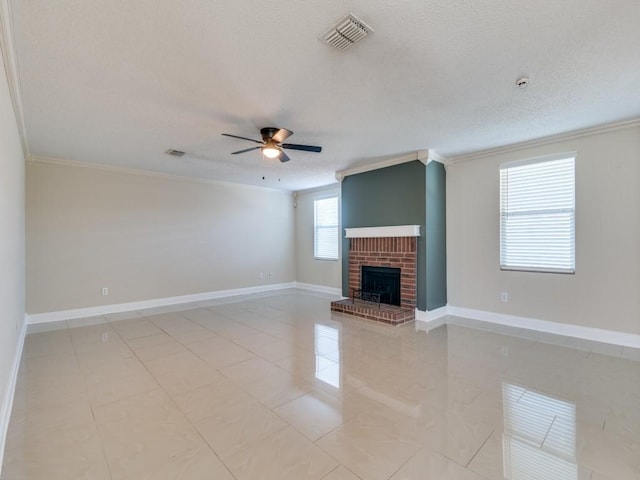 unfurnished living room with a brick fireplace, ceiling fan, ornamental molding, a textured ceiling, and light tile patterned flooring