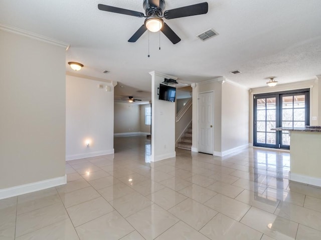 empty room with ceiling fan, ornamental molding, a textured ceiling, and french doors