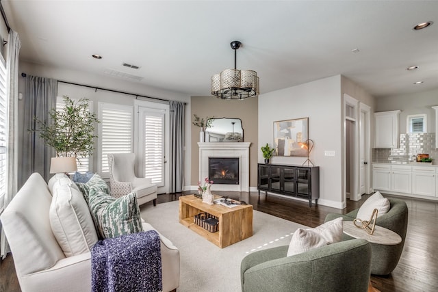 living room with dark hardwood / wood-style floors and a chandelier