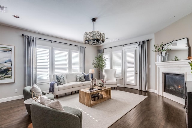 living room with dark wood-type flooring and a notable chandelier