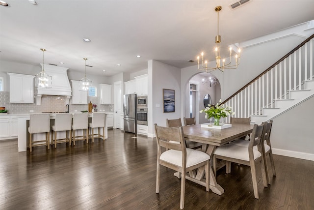 dining room with dark hardwood / wood-style floors and a notable chandelier