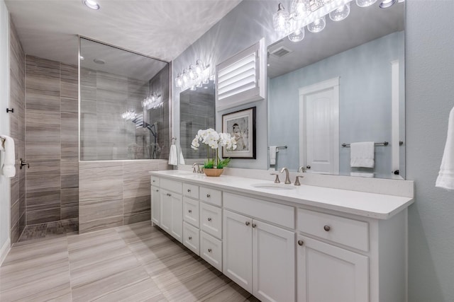 bathroom featuring tiled shower and vanity