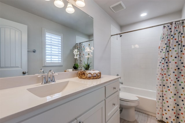 full bathroom featuring shower / tub combo with curtain, vanity, and toilet