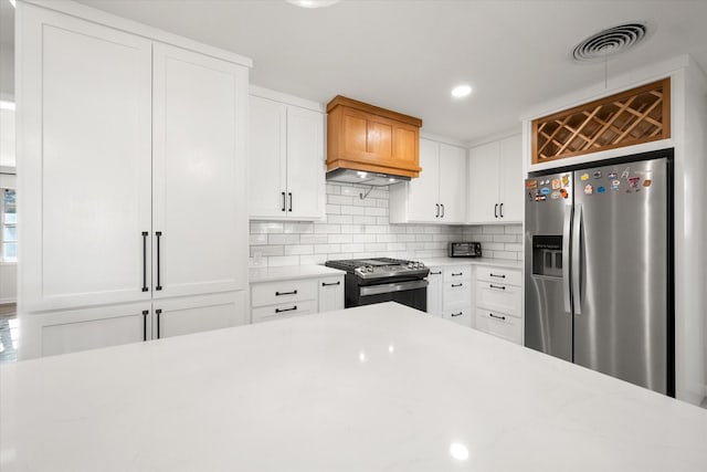 kitchen with white cabinetry, appliances with stainless steel finishes, and decorative backsplash