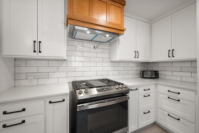 kitchen with gas range, backsplash, custom range hood, and white cabinets