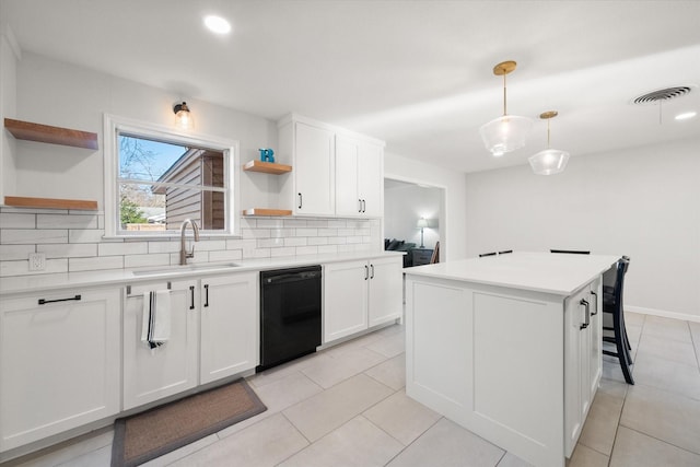 kitchen featuring a kitchen island, white cabinetry, black dishwasher, sink, and hanging light fixtures