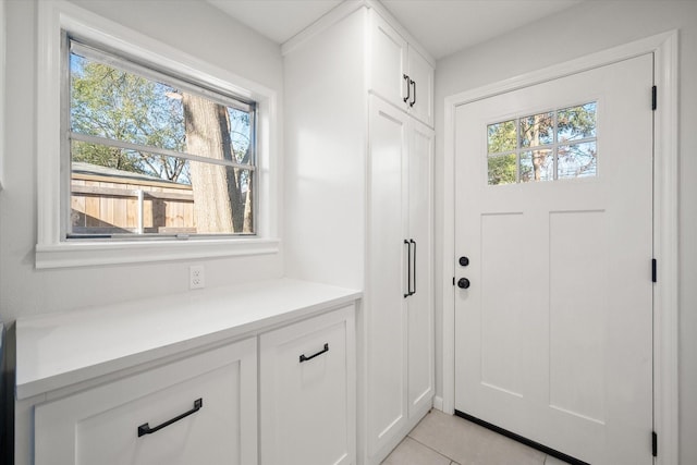 doorway with a healthy amount of sunlight and light tile patterned flooring