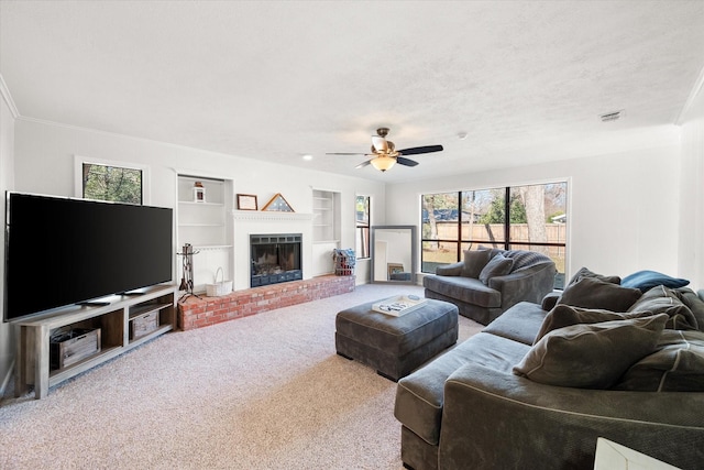 living room with built in features, a fireplace, carpet floors, ceiling fan, and a textured ceiling