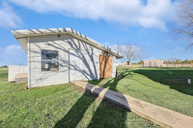 view of property exterior featuring an outbuilding and a lawn