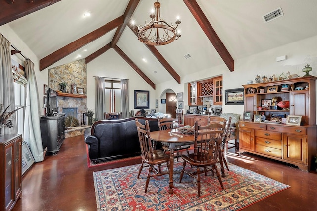 dining space featuring a fireplace, beam ceiling, a chandelier, and high vaulted ceiling