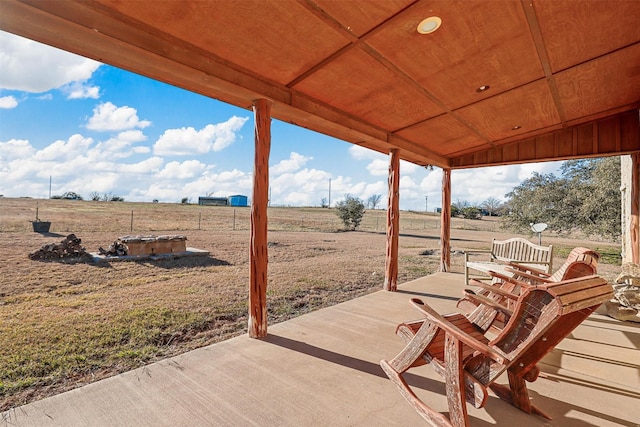 view of patio with a rural view and an outdoor fire pit