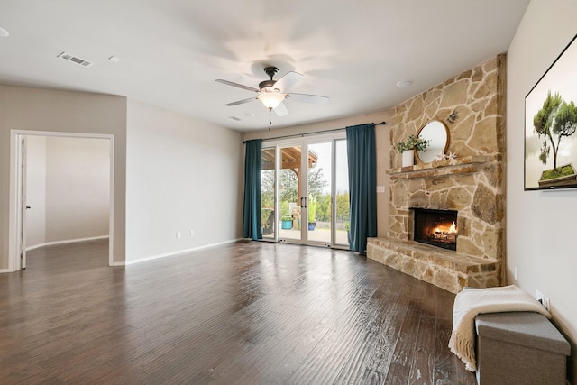 unfurnished living room with wood finished floors, baseboards, visible vents, a fireplace, and ceiling fan