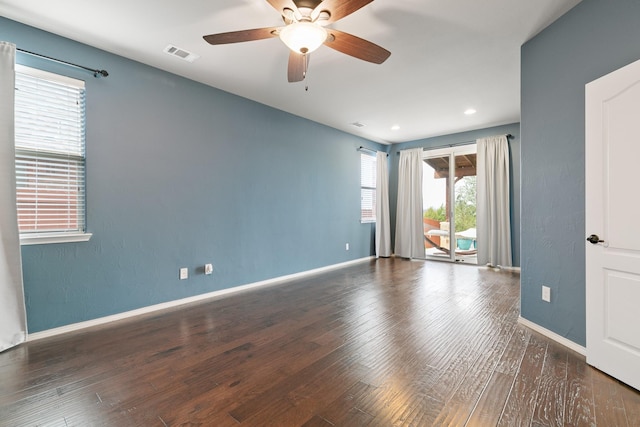 empty room featuring visible vents, baseboards, wood finished floors, and a ceiling fan