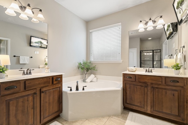 bathroom with tile patterned flooring, a shower stall, a garden tub, and two vanities